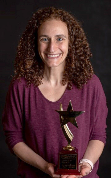 Shari Rogal, MD, MPH standing, holding the Clinical Excellence Award.